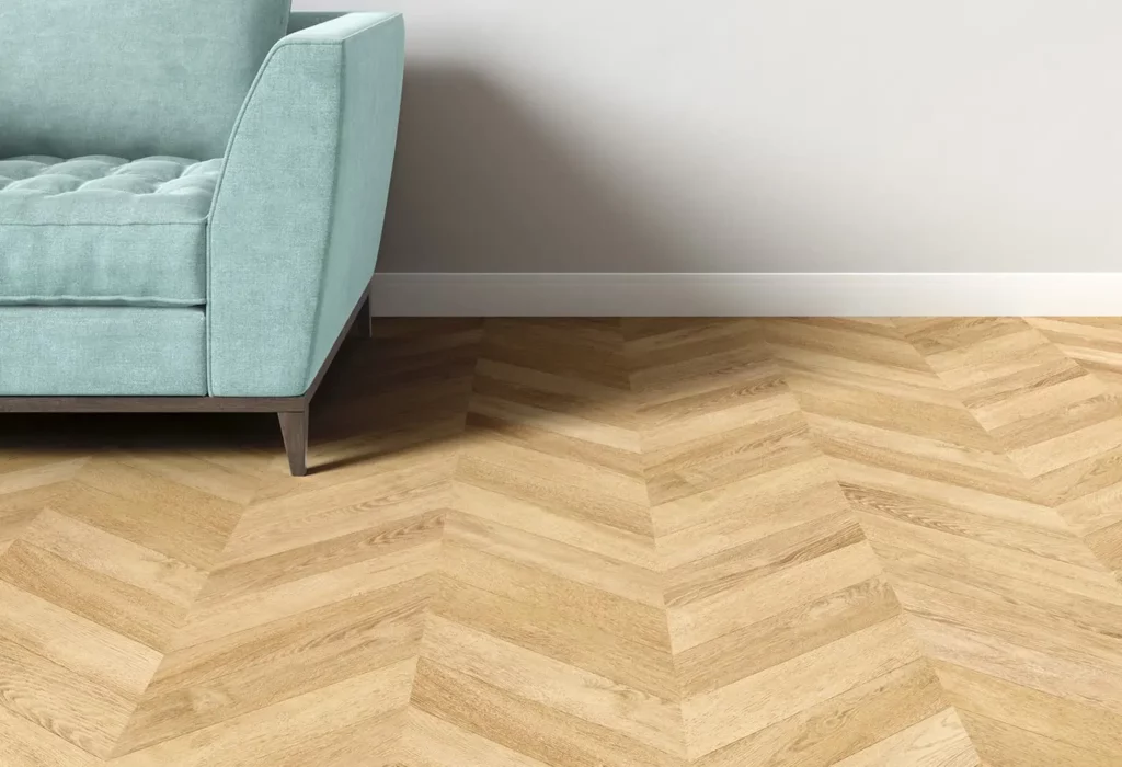 Suelo de parquet en formato espiga junto a un sofá